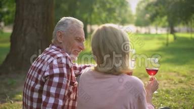 在公园享受浪漫约会和喝酒的退休男女都很高兴